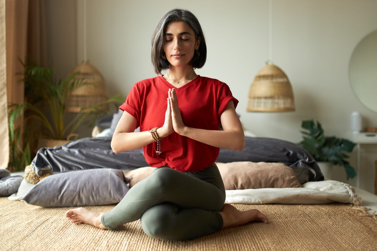 A woman in a red shirt is doing yoga